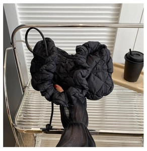 Détail du sac nuage noir matelassé avec bords à volants et cordon de serrage