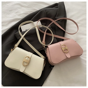 Detail view of cream and pink PU leather shoulder bags with gold oval metal buckles