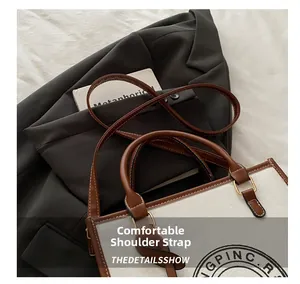 Detail of canvas tote bag with brown leather straps and vintage GPINC.R letter print