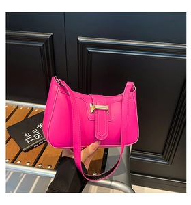 Gros plan du sac sous le bras rose vif avec boucle dorée et texture en cuir lisse