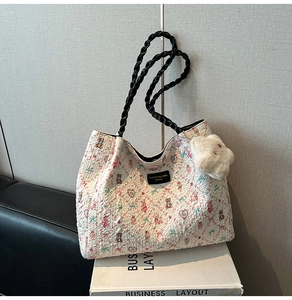Detail of white tote bag with bear print and soft floral texture featuring plush charm