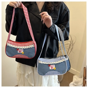 Detail of red and blue checkered baguette bags with lace trim and cherry embroidery