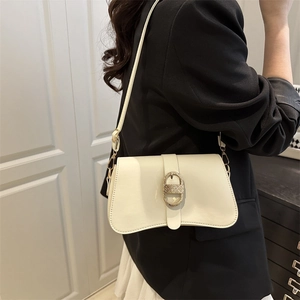 Chic cream white leather underarm bag with gold oval buckle shown on a model