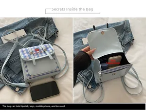 Detail view of large capacity blue plaid crossbody backpack showing interior main pocket