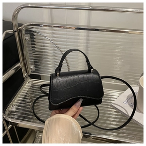 Detail of black faux leather mini square bag with crocodile pattern and silver hardware