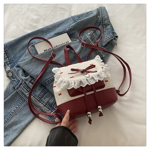 Detail of red and white balletcore backpack with lace trim and heart charm