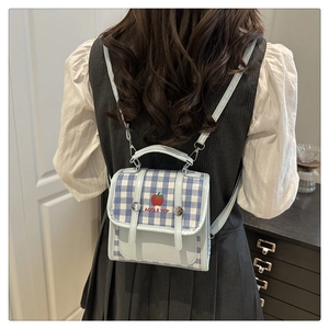 Close-up of blue plaid canvas backpack with apple pattern and decorative straps