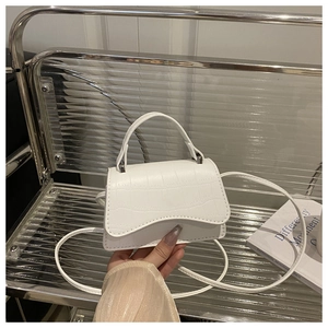 Close-up of white croc-embossed mini crossbody bag with sleek metallic hardware