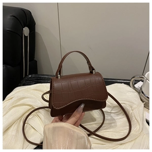 Detail of coffee brown crocodile pattern mini crossbody bag with shiny finish