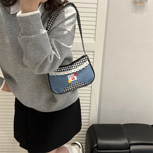 Vintage denim checkered shoulder bag with lace trim and cherry patch worn by model