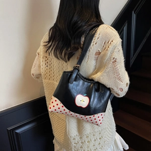 Cute apple dot pattern black tote bag for women showing a casual 45-degree model view