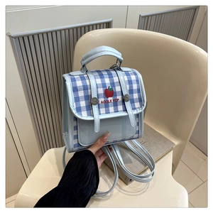 Detail of light blue plaid mini backpack with apple print and adjustable straps