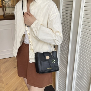 Modische schwarze Eimer-Tasche für Damen mit Blumenanhänger und seidigem Schaldekor am Griff