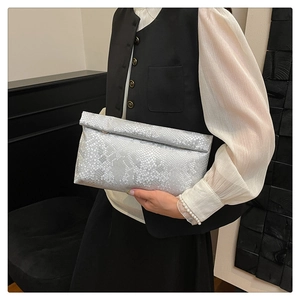Detail of silver snake skin texture leather on a stylish foldable envelope clutch bag