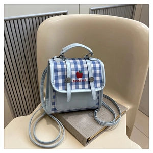 Close-up of blue gingham crossbody bag with apple embroidery and faux leather straps