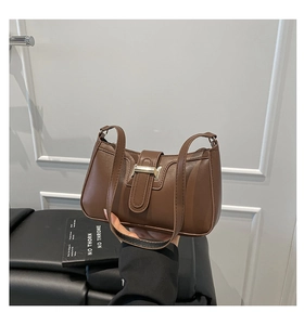 Close-up of brown leather shoulder bag with gold metal buckle and vintage belt detail