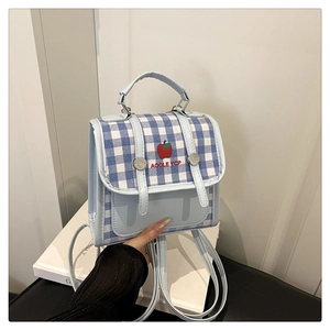 Close-up of blue plaid backpack with apple embroidery and light blue leather handle