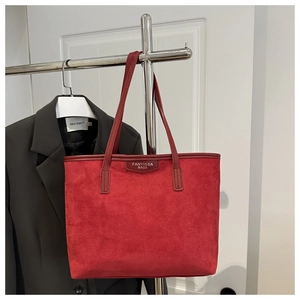 Detail of red suede tote bag with shoulder straps and FANYISSA BAGS logo print