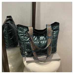 Dettaglio borsa tote trapuntata verde scuro lucido con tracolla in tessuto floreale