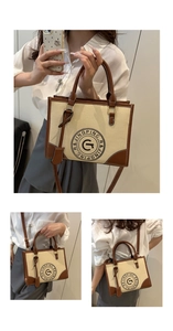 Detail view of large canvas tote bag with brown leather trim and circular letter print