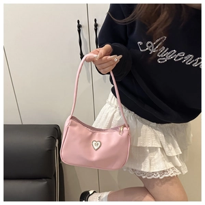 Detail showing pink baguette bag with heart-shaped diamond ornament and gold trim
