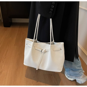 Detail of white lychee pattern tote bag with buckle strap showing large capacity