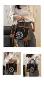 Detail of vintage canvas tote bag with contrast leather trim and printed emblem