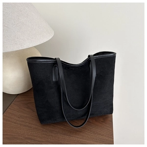 Détail du sac cabas en daim noir montrant l'étiquette en cuir Fanyissa et la couture