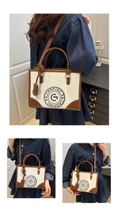 Detail of vintage canvas tote bag with brown leather trim and circular logo print