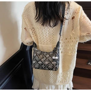 Close-up of ethnic geometric print on shoulder bag with decorative black and white charms
