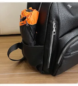 Close-up of side pocket on black lychee texture backpack holding a folded umbrella