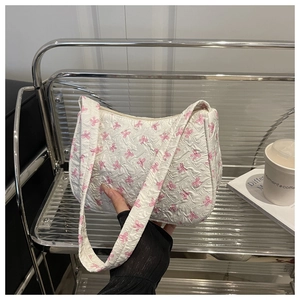 Close-up of white pleated shoulder bag with pink bow prints and matching strap