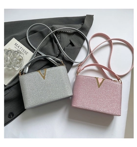 Detail of glitter sequin handbag with gold V-logo in silver and pink colors