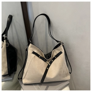Detail of minimalist tote bag with off-white suede texture and black leather V-strap