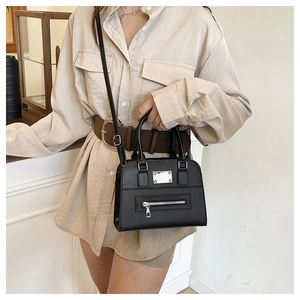 Close-up of black leather crossbody tote featuring silver hardware and adjustable strap