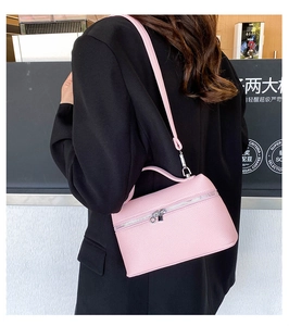 Close-up of pink lychee grain leather crossbody bag with silver zipper and top handle