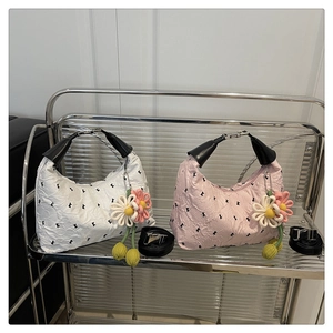 Detail view of stylish pleated crossbody bags in white and pink with floral charms