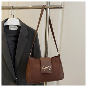 Brown vintage shoulder bag with suede patchwork and golden bow buckle on metal hanger