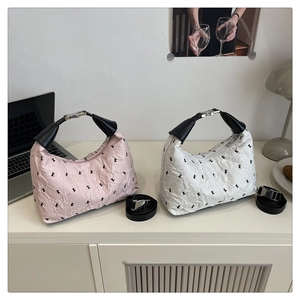 Detail of stylish dumpling bags with bunny embroidery and silver metal buckles