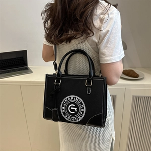 Retro canvas tote bag with letter print and dual handles in urban lifestyle setting