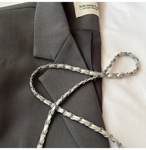 Close-up of the woven silver metal chain strap with grey leather on denim bag