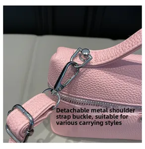 Detail of pink lychee leather handbag with detachable silver metal hardware buckle