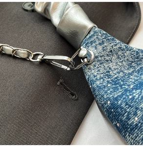 Vue macro du denim bleu avec strass et détails de la bandoulière en chaîne argentée