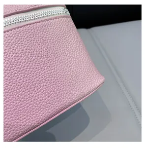 Close-up of pink litchi grain leather bag with silver zipper and fine stitching