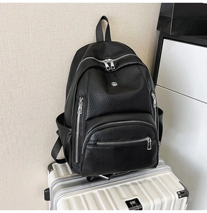 Close-up of litchi texture waterproof backpack placed on a silver suitcase