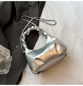Détail du sac à main plissé argenté avec bandoulière chaîne et texture cuir métallisé