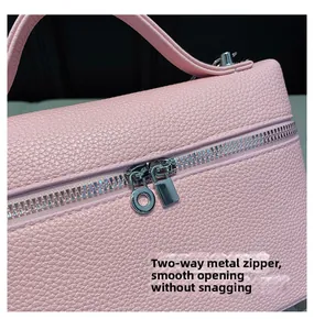 Detailed close-up of smooth pink litchi grain leather bag with dual metal zipper