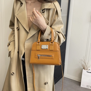 Chic ginger yellow crossbody tote bag shown on a model wearing a khaki trench coat
