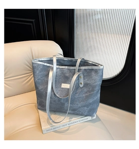 Dettaglio della borsa tote blu vintage con manici argentati ed etichetta tessuta FASHION