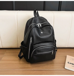 Detailed close-up of a black lychee texture backpack with multiple silver zippers